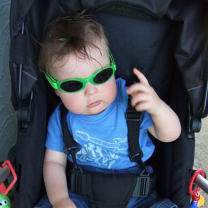 baby in stroller wearing lime sunglasses