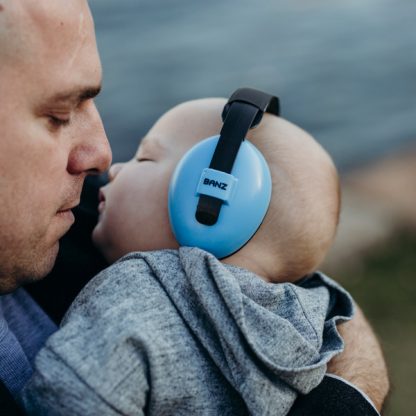 Father holding sleeping baby wearing Blue Mini Earmuffs