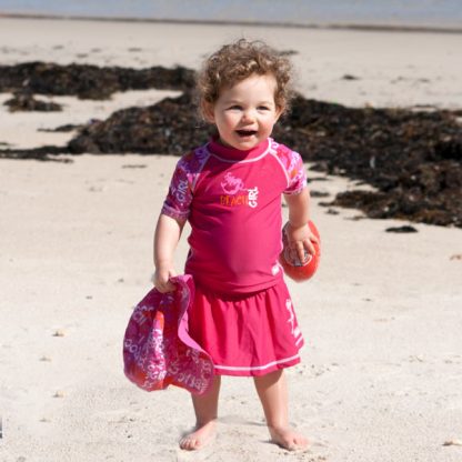 Toddler in a short-sleeved Pink Graffiti rash shirt and swim skirt