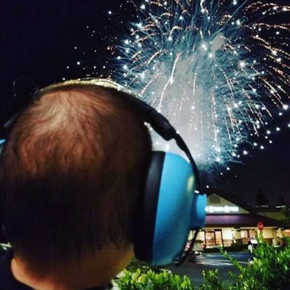 Baby wearing blue Mini Earmuffs watching fireworks